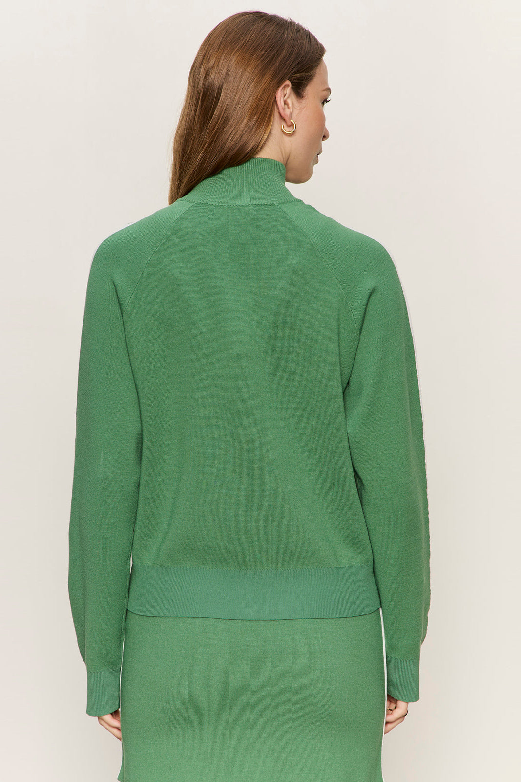 Woman wearing a green outfit against a plain background