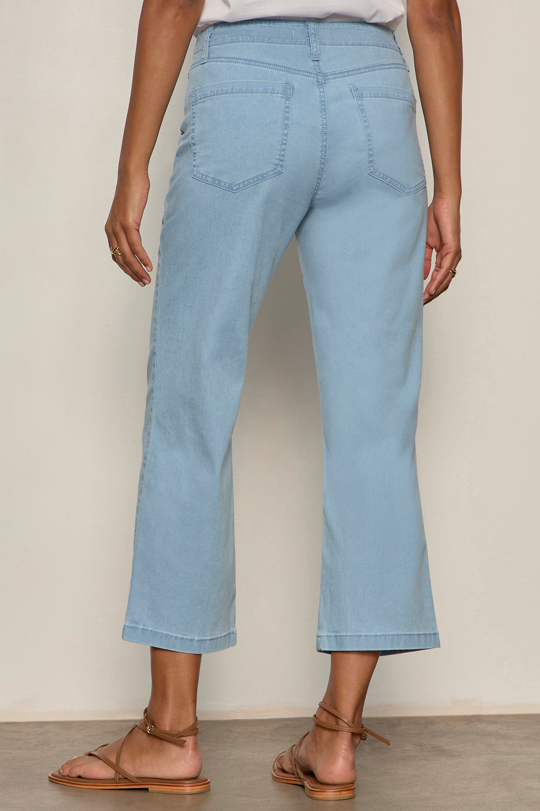 Light blue jeans worn by a person on a plain background