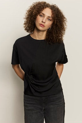Person wearing a black t-shirt against a plain background