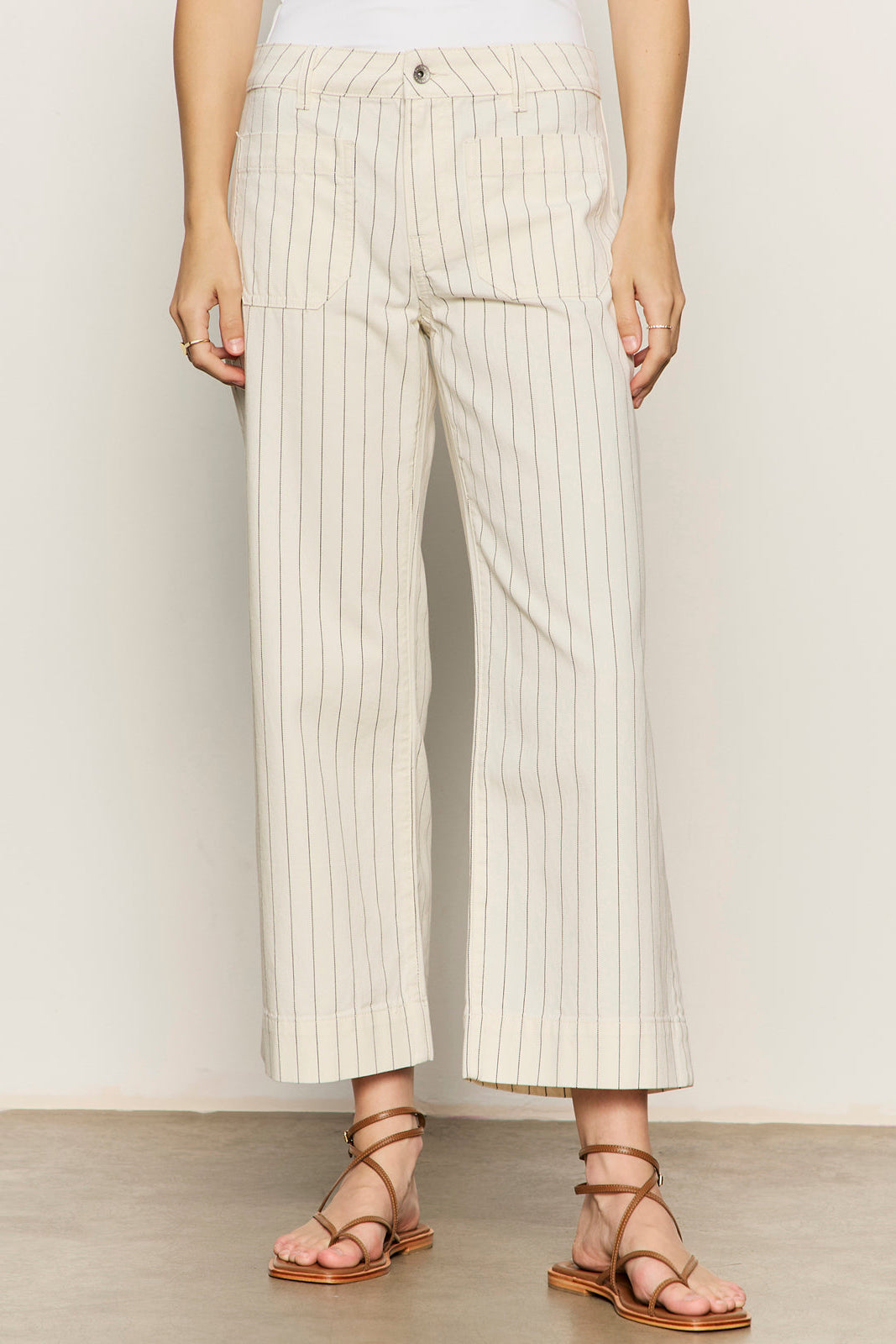 Person wearing white pinstripe pants with a plain background