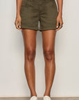 Person wearing olive green shorts on a plain background