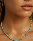 Close-up of a woman wearing a turquoise beaded necklace.