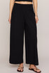Person wearing black wide-leg pants on a plain background