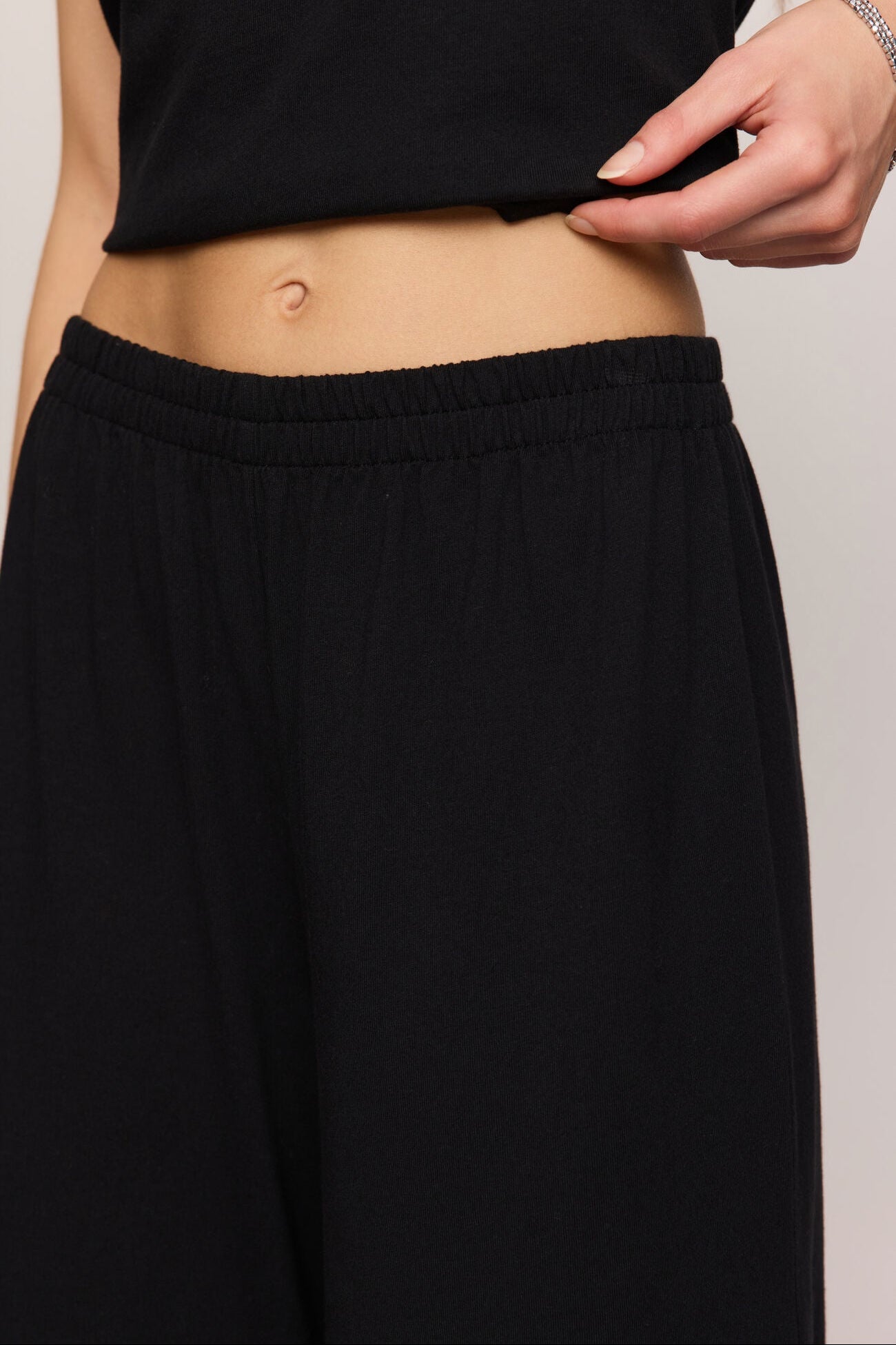 Person wearing a black skirt with a plain background
