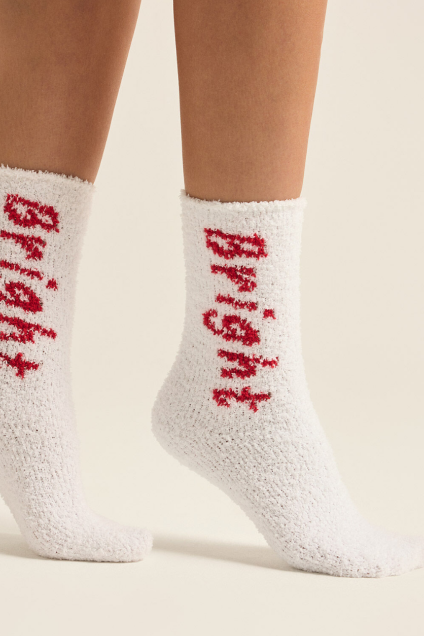 A pair of white plush socks with the word 'BRIGHT' written in red on the side.