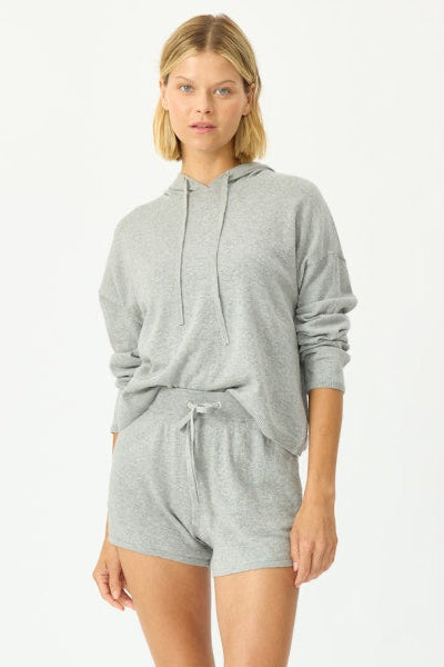 Woman wearing a gray hoodie and shorts set on a white background