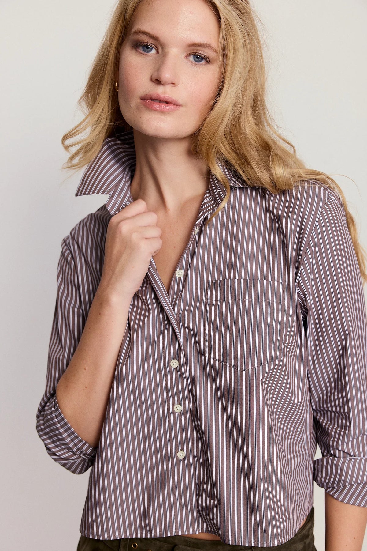 Woman wearing a striped shirt against a plain background