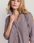 Woman wearing a striped shirt against a plain background
