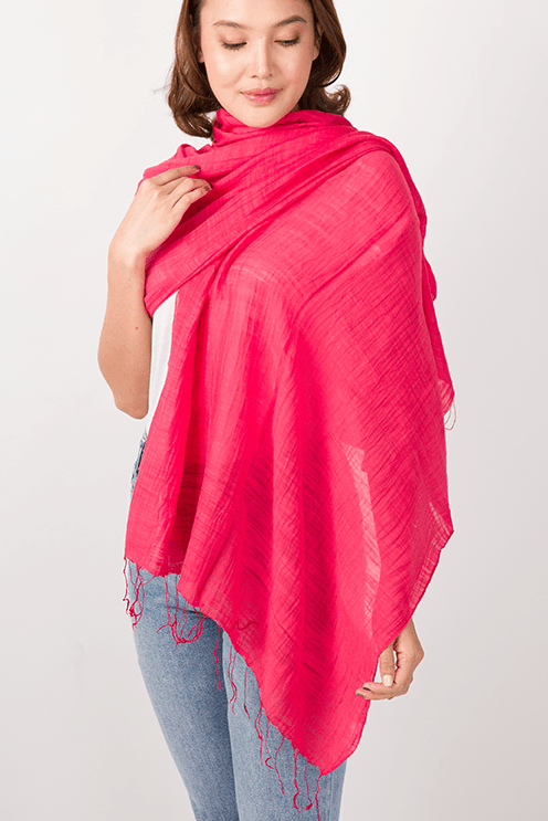 Woman wearing a bright pink scarf on a white background