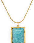 Gold necklace with a blue pendant on a white background