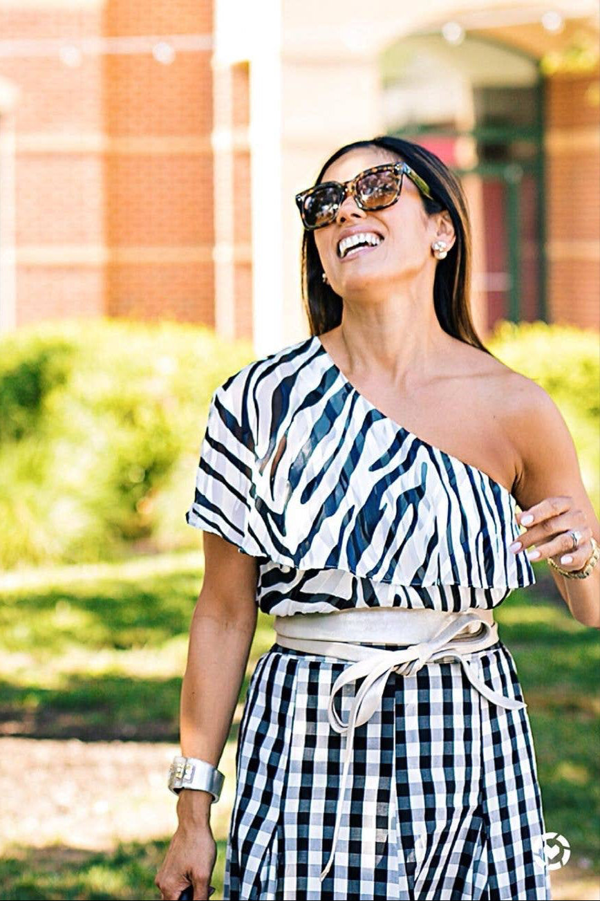 Woman wearing a black and white patterned dress outdoors.