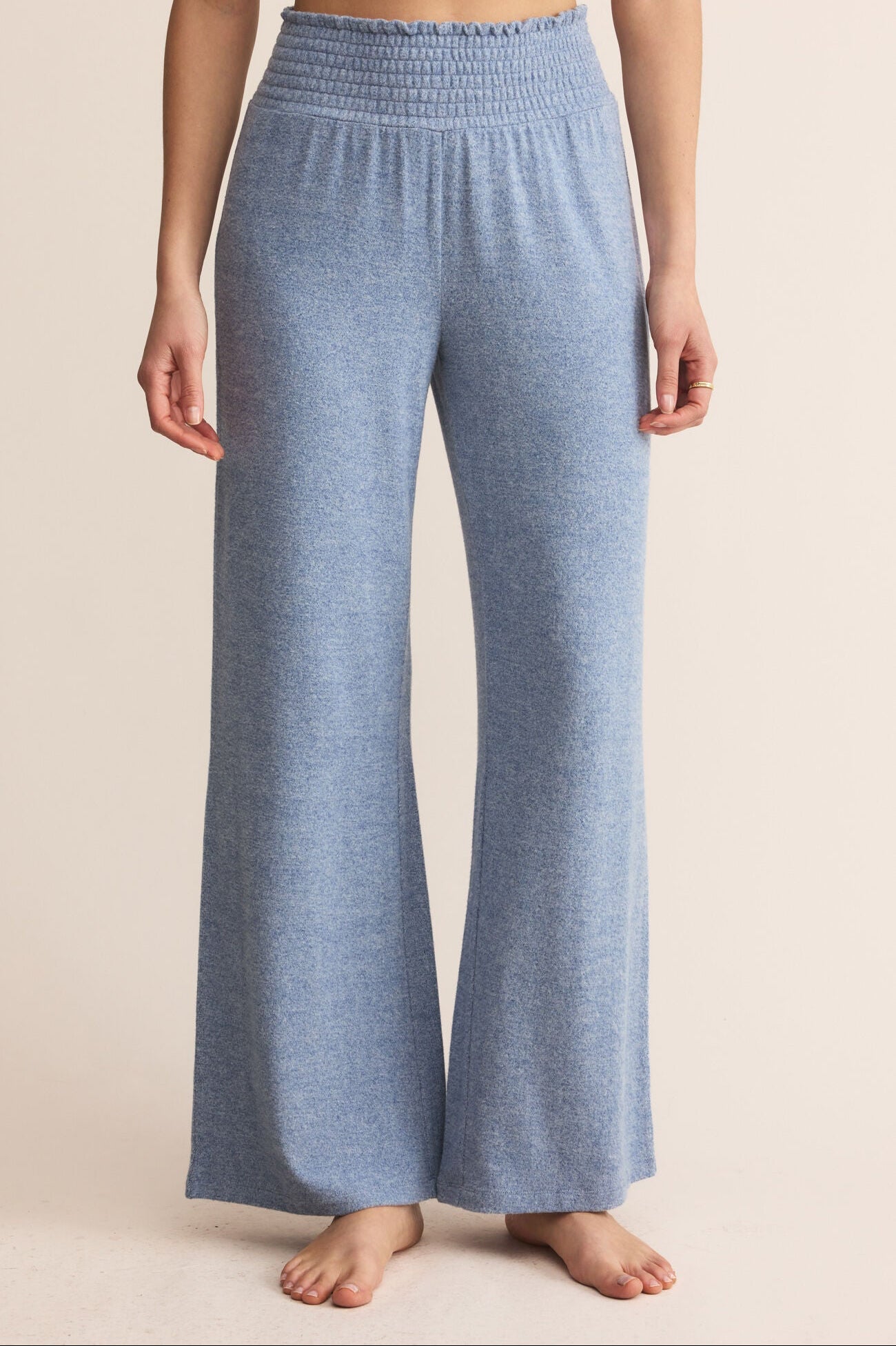 Blue lounge pants worn by a person on a beige background
