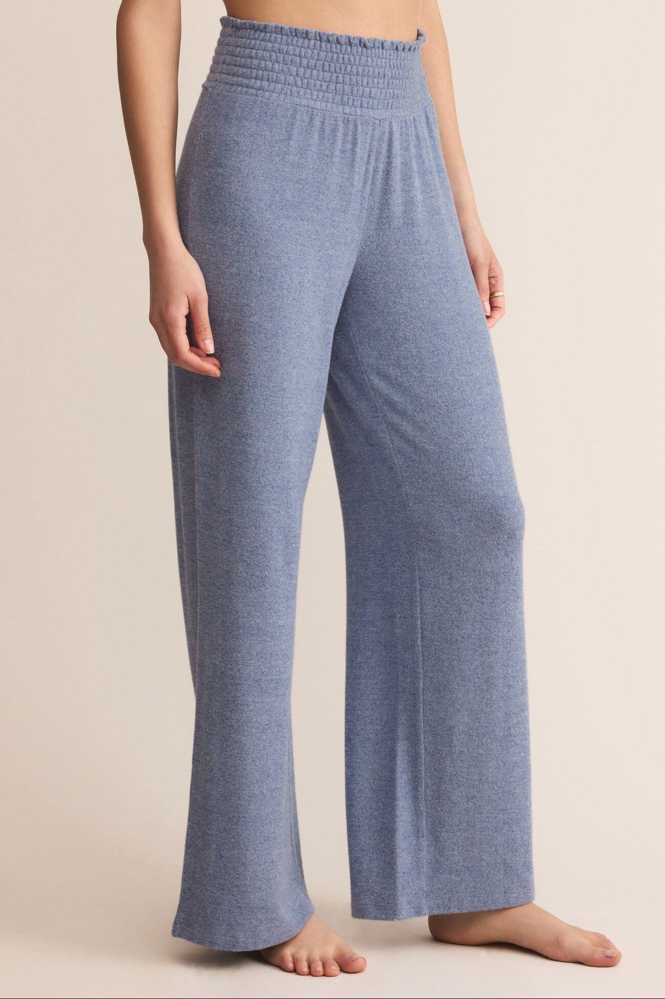 Blue lounge pants worn by a person on a beige background