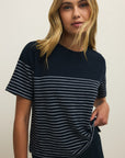 Woman wearing a navy blue and white striped t-shirt against a plain background