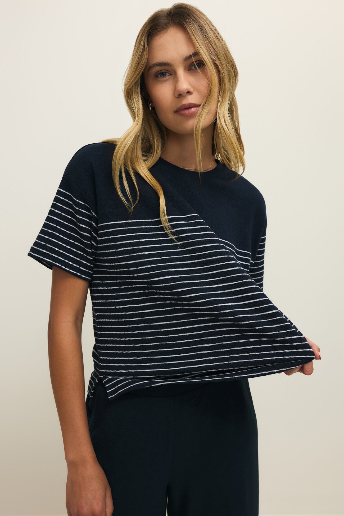 Woman wearing a black and white striped t-shirt against a plain background