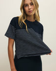 Woman wearing a black and white striped t-shirt against a plain background