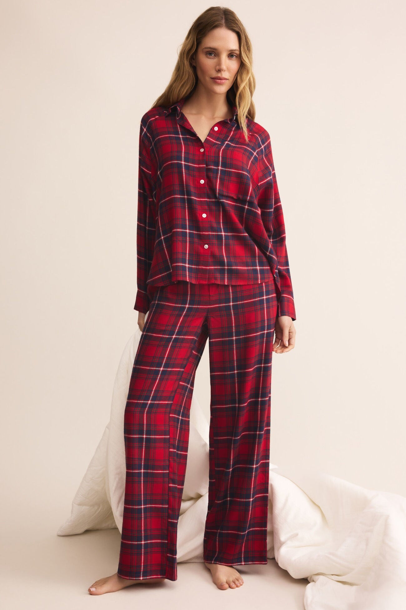 Woman wearing red plaid pajamas on a white background
