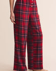 Red plaid pajama pants worn by a person on a beige background