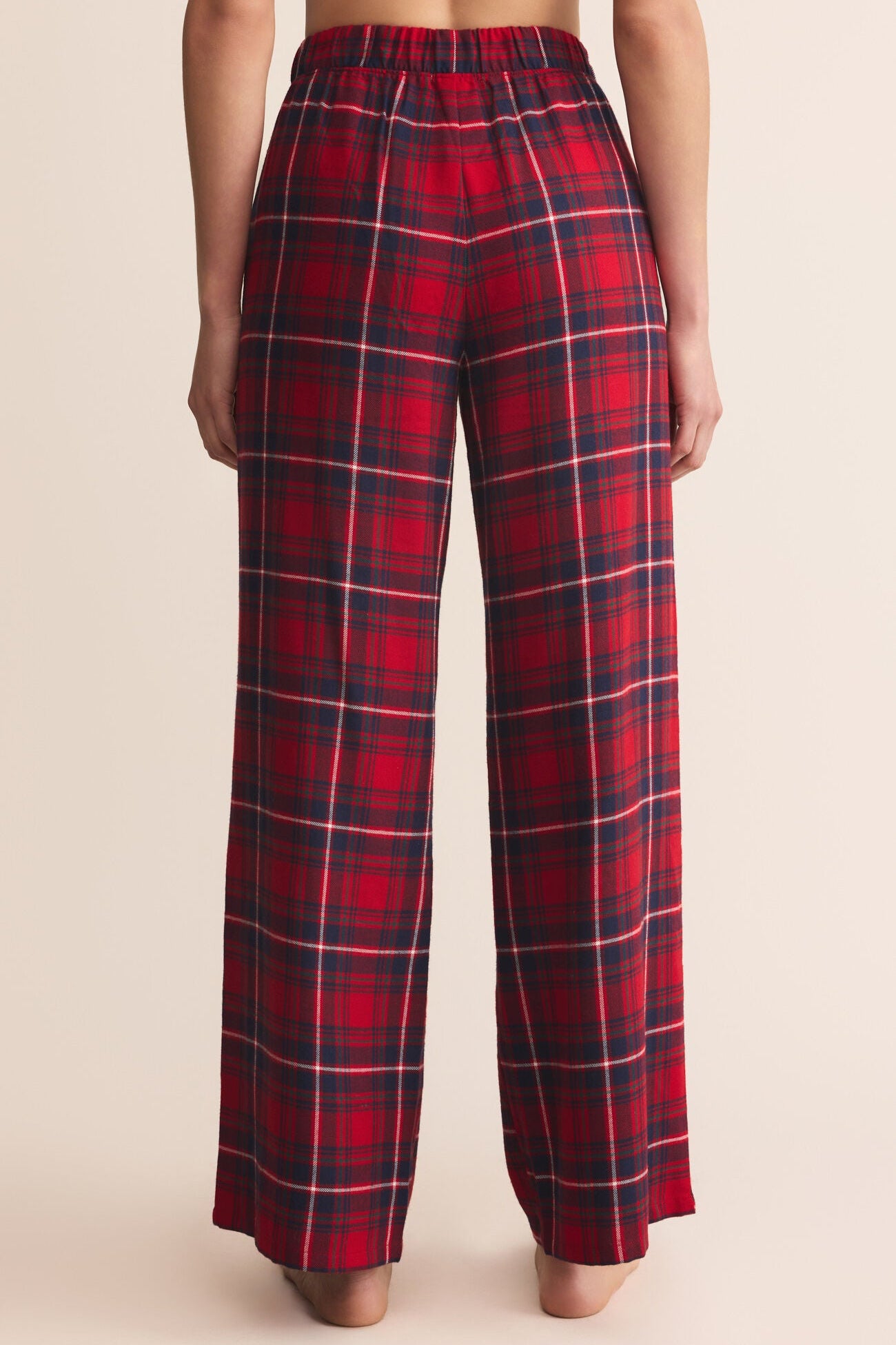 Red plaid pants worn by a person on a beige background