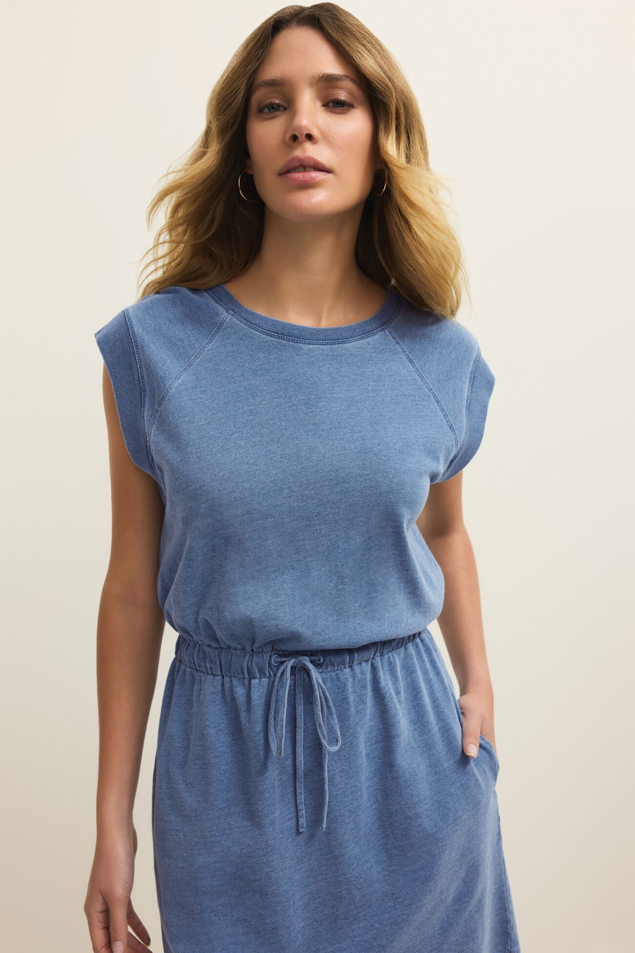 Woman wearing a blue dress against a plain background