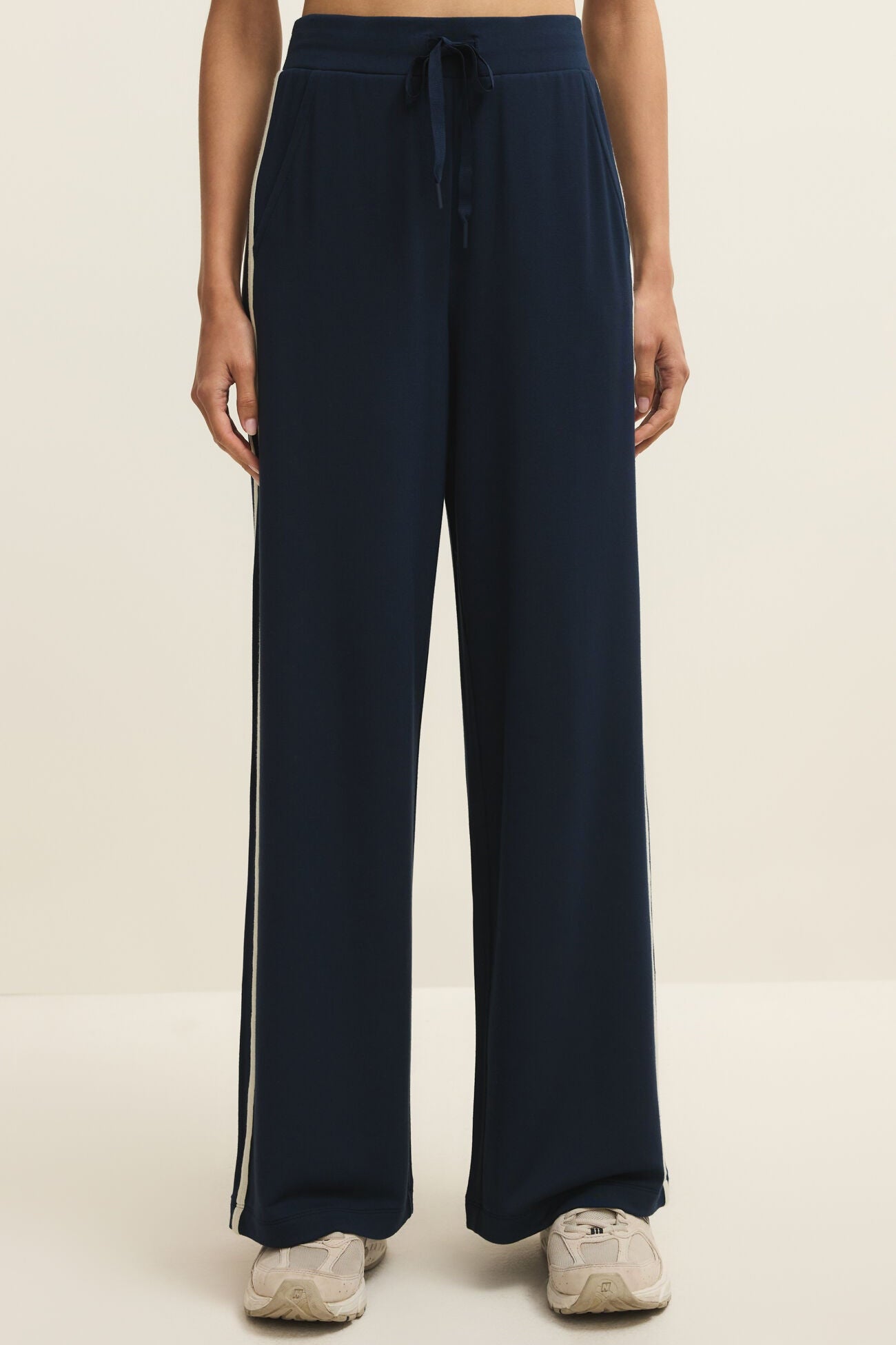 Navy blue pants with white stripes on a beige background