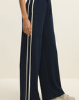 Navy blue wide-leg pants with white stripes on a neutral background