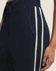 Navy blue pants with a white stripe on a neutral background