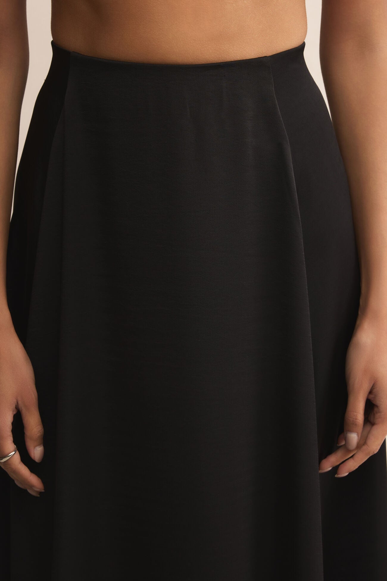 Black skirt worn by a person against a neutral background