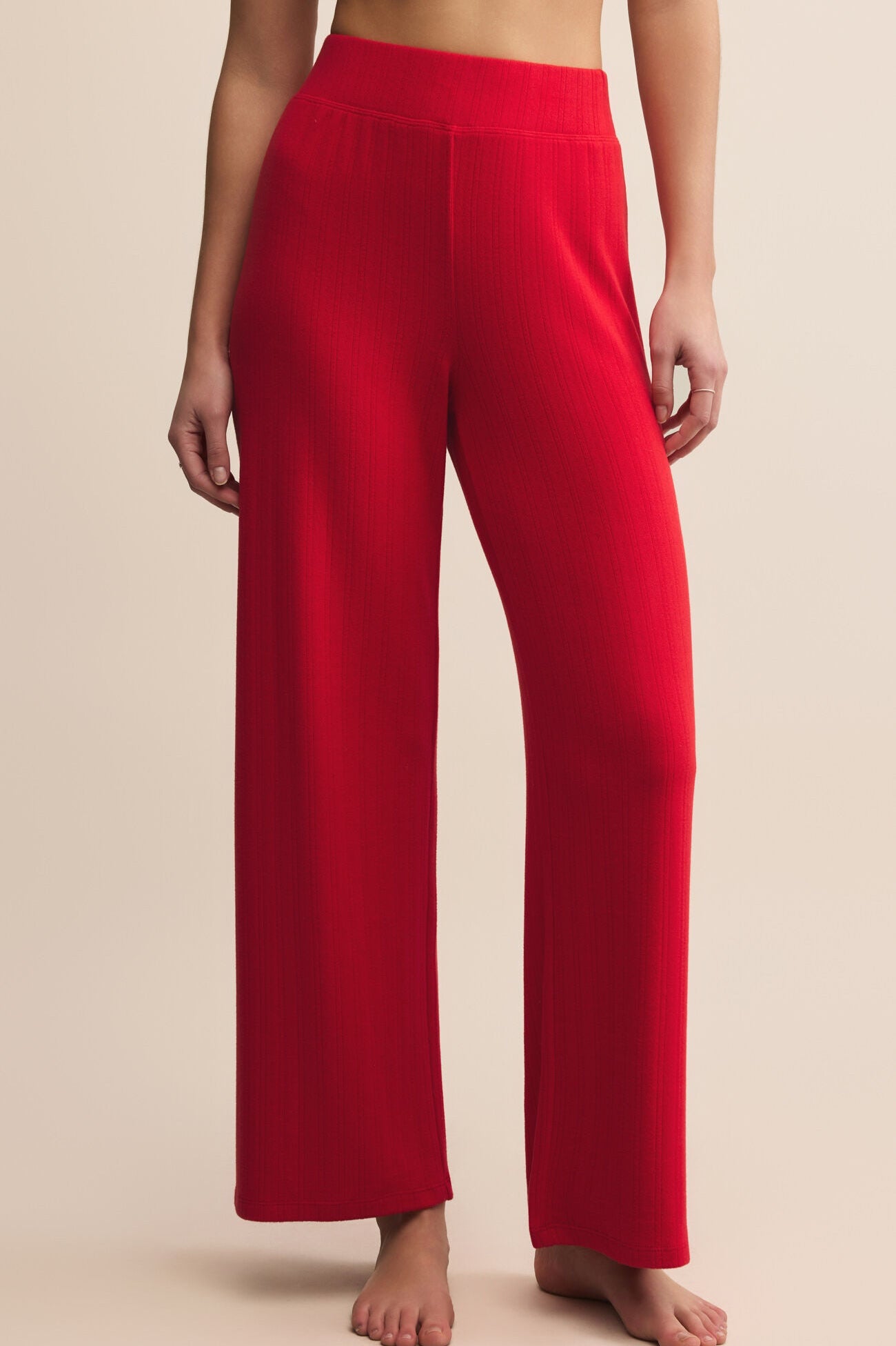 Red pants worn by a person on a beige background
