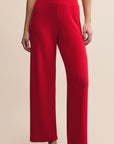 Red pants worn by a person on a beige background