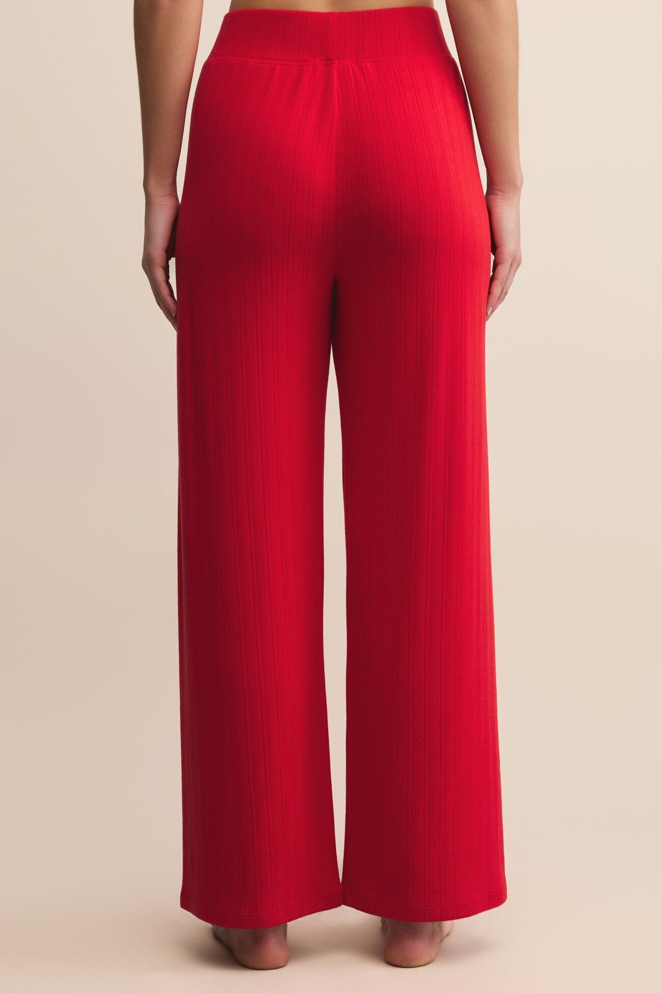 Red wide-leg pants worn by a person on a beige background