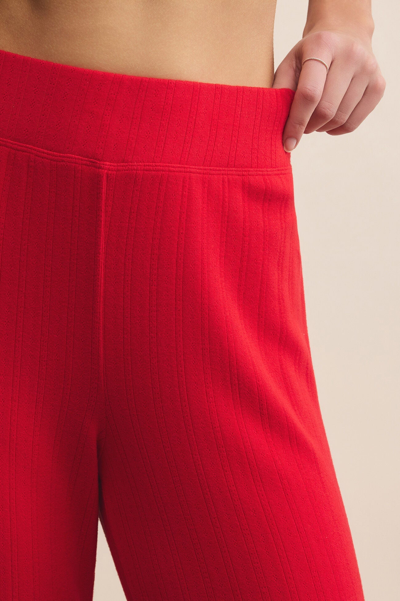 Red pants being worn against a beige background