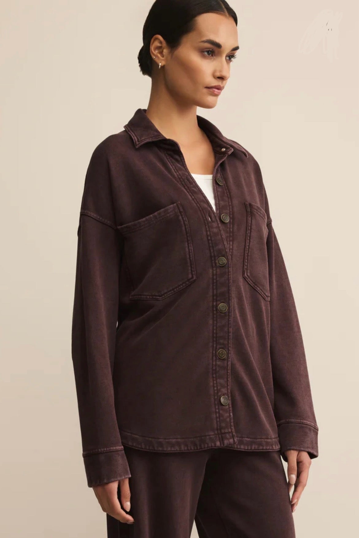 Woman wearing a brown jacket on a beige background