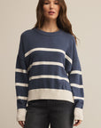 Woman wearing a blue and white striped sweater against a beige background