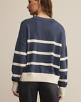 Person wearing a navy and white striped sweater on a beige background
