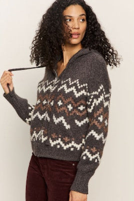 Woman wearing a patterned sweater against a plain background