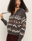 Woman wearing a patterned sweater against a plain background