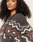 Woman wearing a patterned sweater against a plain background