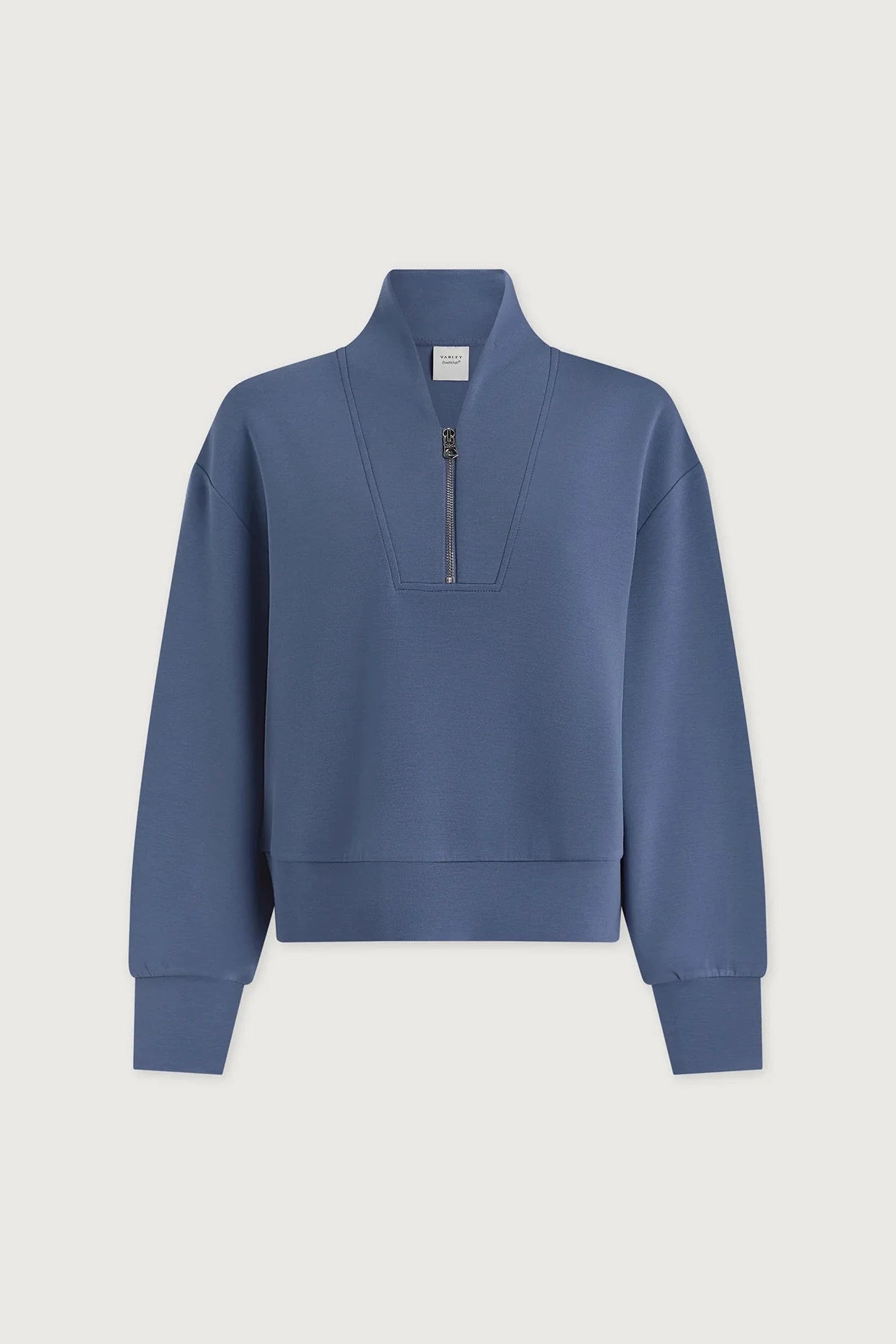 Blue sweatshirt with a quarter zip on a light gray background