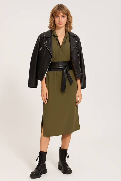 Woman wearing a green dress with a black leather jacket and boots on a white background
