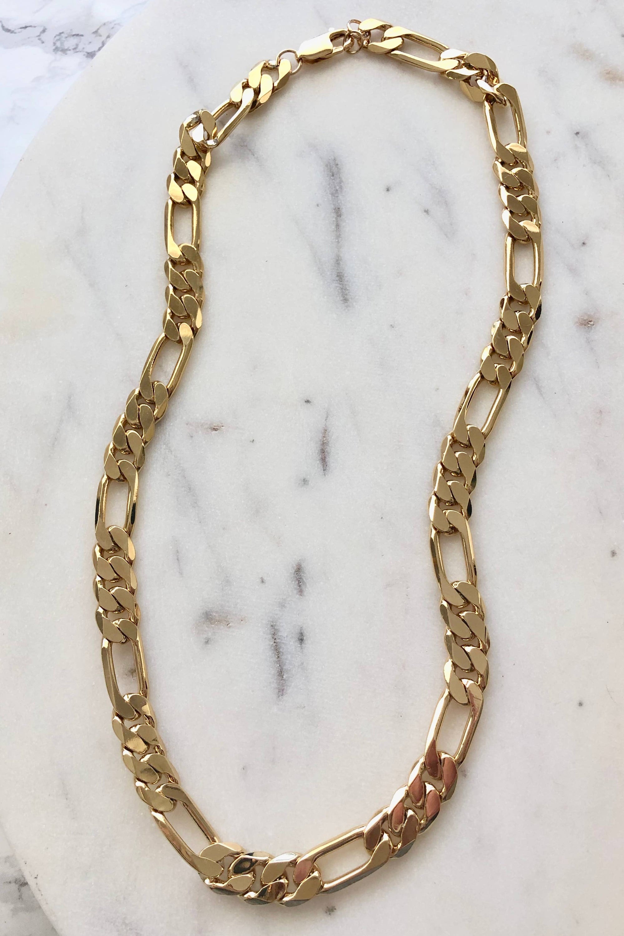 Gold chain necklace on a marble surface