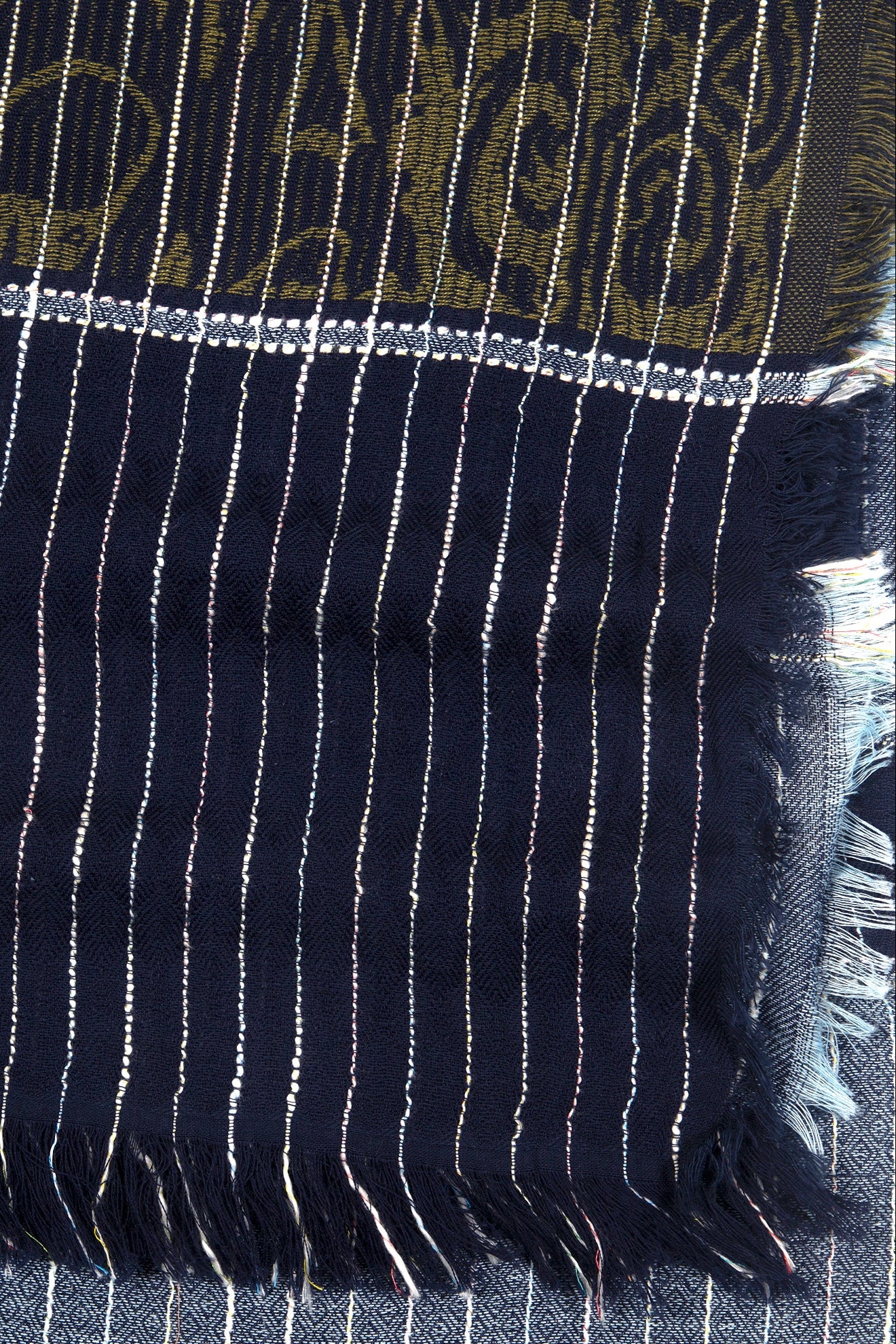 Close-up of a dark blue fabric with white stripes and intricate patterns.