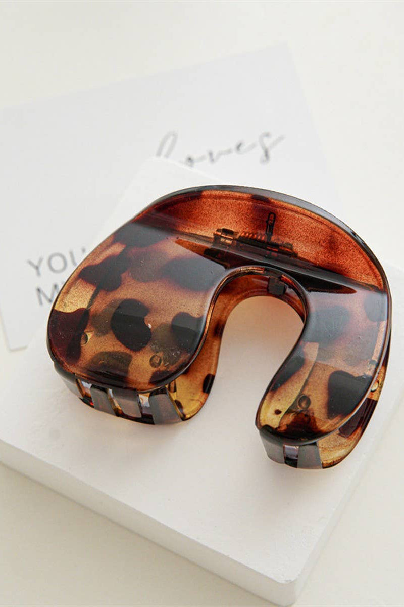 Tortoiseshell neck pillow on a white surface with a blurred background