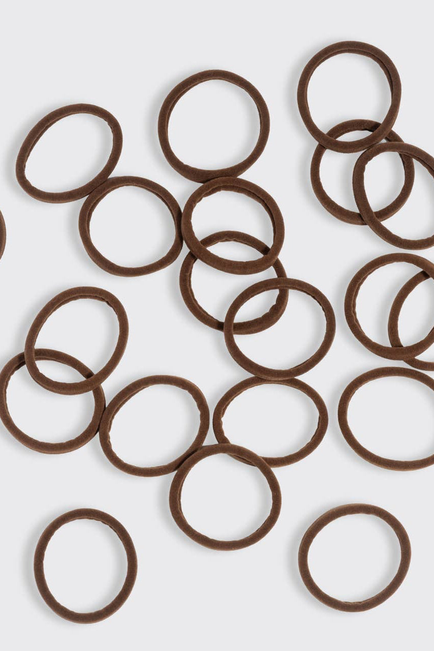 Brown rubber bands scattered on a white background