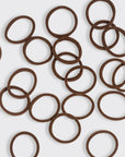 Brown rubber bands scattered on a white background
