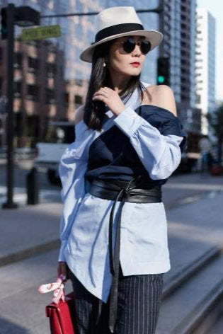 Woman in stylish outfit with hat and sunglasses on a city street