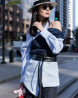 Woman in stylish outfit with hat and sunglasses on a city street