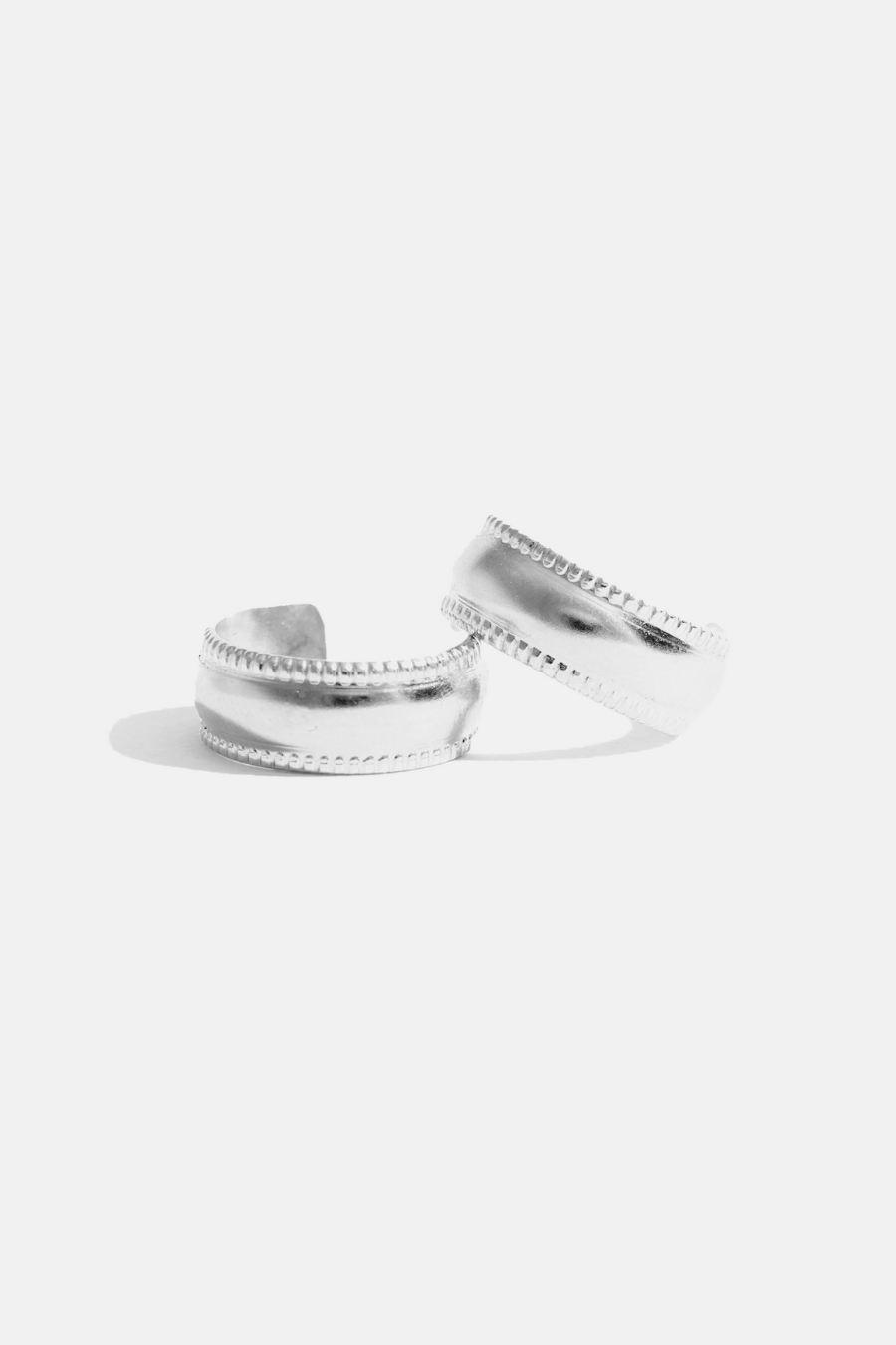 A pair of chunky silver-colored hoop earrings with textured edges, displayed against a white background.