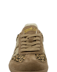 A single low-top sneaker shown from the front on a plain white background. The shoe is primarily tan and brown suede with a leopard print pattern on the toe box and side panels, plus a cream collar and yellow script branding on the tongue.