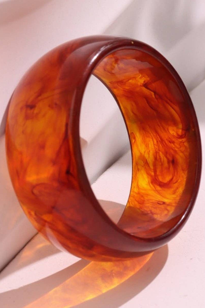 Amber-colored bangle on a light fabric background